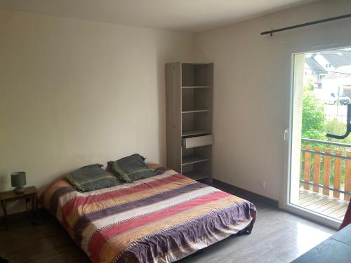 une chambre avec un lit et une grande fenêtre dans l'établissement Spacieux T2, agréable et lumineux, à Villard-de-Lans