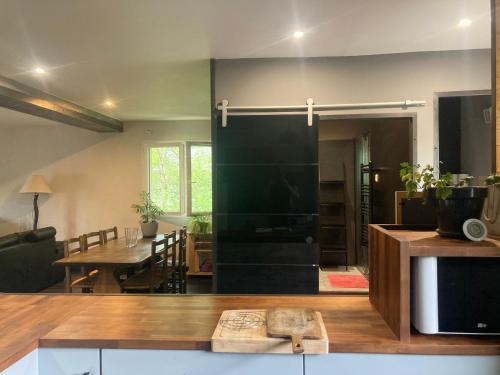 une cuisine et une salle à manger avec un grand réfrigérateur noir dans l'établissement Spacieux T2, agréable et lumineux, à Villard-de-Lans