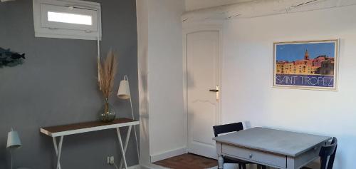 Cette chambre comprend une table et une porte blanche. dans l'établissement Au cœur de St Tropez, à Saint-Tropez