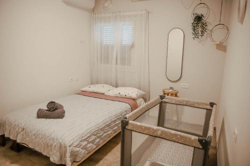 a small bedroom with two beds and a mirror at בגג העמק - וילה in HaZore‘im