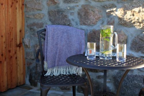 a table with glasses and a vase on it at The Stable Bothy in Rogart