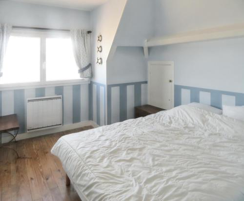 1 dormitorio con cama blanca y ventana en Maison de 6 chambres avec vue sur la mer jardin clos et wifi a Arromanches les Bains, en Corneville-sur-Risle