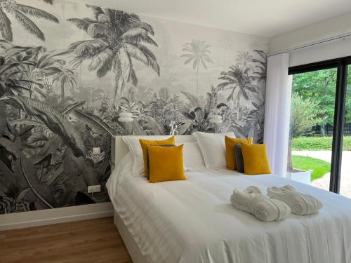 - une chambre avec un grand lit blanc et des oreillers jaunes dans l'établissement LA VILLA DIANE, Maison d'hôtes, Bed and Breakfast, à Montauban