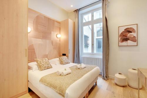 une chambre avec un lit avec deux animaux en peluche dessus dans l'établissement Vivez une expérience au coeur de la vie parisienne, à Paris