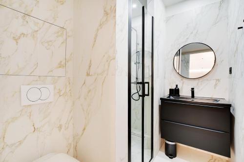 une salle de bain avec une douche, un lavabo et un miroir dans l'établissement Vivez une expérience au coeur de la vie parisienne, à Paris