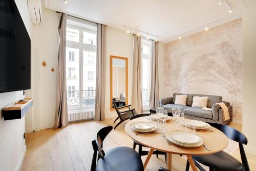 un salon avec une table, des chaises et un canapé dans l'établissement Vivez une expérience au coeur de la vie parisienne, à Paris