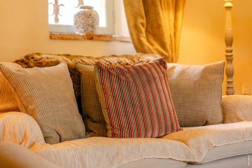 a couch with a bunch of pillows on it at Maison Augustine - 300m2- Lisle-sur-Tarn in Lisle-sur-Tarn