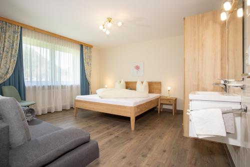 ein Schlafzimmer mit einem Bett und ein Badezimmer mit einem Waschbecken in der Unterkunft Appart Lechner in Pertisau