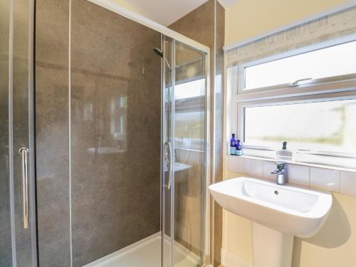 a bathroom with a sink and a shower at Compass Cottage in Aldeburgh