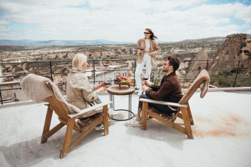 a group of people sitting around a table on a roof at Millstone Cave Suites Hotel in Uchisar