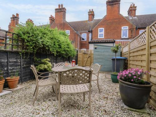 a small backyard with a table and chairs at Compass Cottage in Aldeburgh