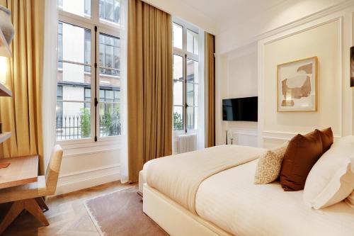 une chambre avec un lit et deux fenêtres dans l'établissement TheLander - Serviced Apartments in Louvre, à Paris