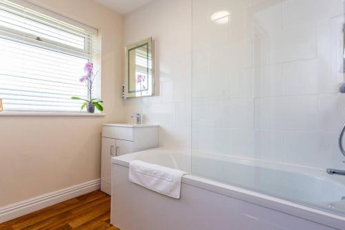 uma casa de banho branca com uma banheira e uma janela em 3Bedroom House Stockton On Tees for Work & Leisure em Stockton-on-Tees