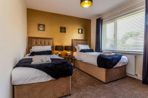 um quarto com 2 camas e uma janela em 3Bedroom House Stockton On Tees for Work & Leisure em Stockton-on-Tees