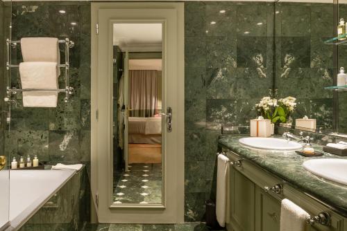 a bathroom with two sinks and a tub and a mirror at Althoff Hotel Villa Belrose in Saint-Tropez