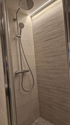 a shower with a shower head in a bathroom at Moderne F3 - 10 min aeroport CDG - Paris - Parc Astérix - Disneyland Paris - Tour Eiffel - Champs Elysée - 15 min Parc des expositions Villepinte - 10 min Le Bourget - 5 min du Golf international de Roissy- JO 2024 in Le Thillay