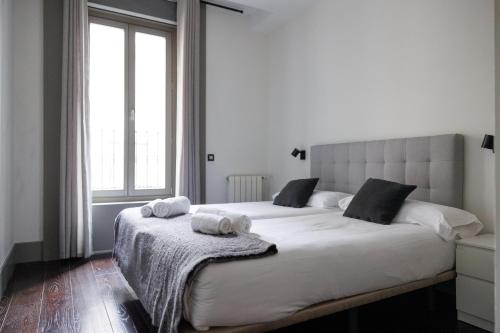 a bedroom with a large white bed with towels on it at Slow Suites Gran Vía in Madrid
