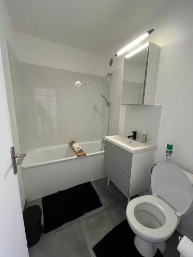 une salle de bain blanche avec toilettes et baignoire dans l'établissement Le Montreuillois ! Parking privé et Métro à proximité, à Montreuil
