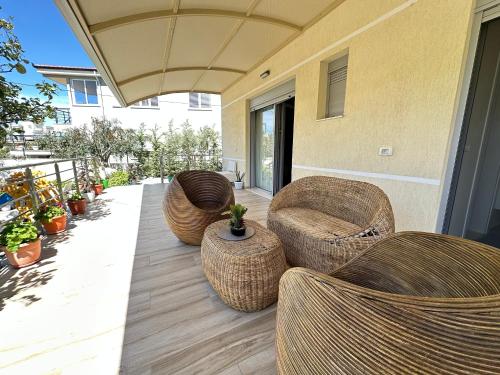 a patio with wicker chairs and a table at Arial Trinity Suites in Vlorë