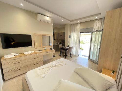 a bedroom with a bed with a television and a table at Arial Trinity Suites in Vlorë