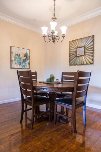 a dining room table with chairs and a chandelier at Gated Condo Heated Pool Putt Green Near Papago in Phoenix