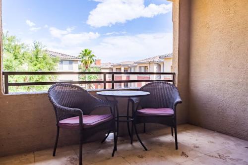 a balcony with a table and two chairs and a window at Gated Condo Heated Pool Putt Green Near Papago in Phoenix