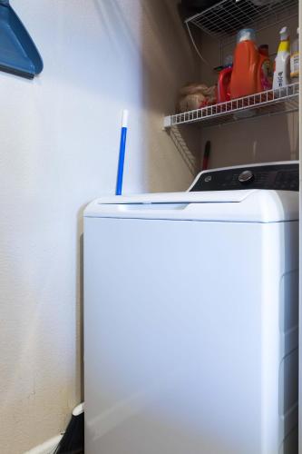 a white refrigerator with a blue straw in a kitchen at Gated Condo Heated Pool Putt Green Near Papago in Phoenix