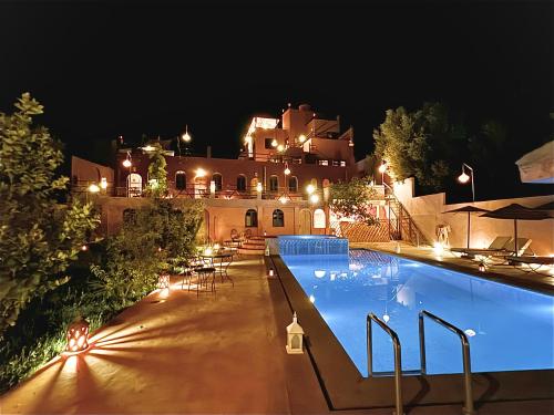 uma casa grande com piscina à noite em Riad Sahara Stars Dades em Boumalne Dadès
