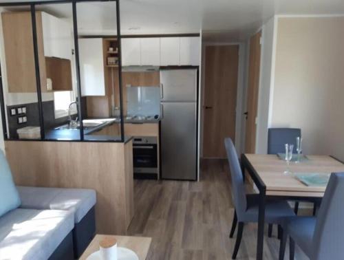 un salon avec une table et une cuisine dans l'établissement Vacances de rêve au bord de mer, à Saint-Jean-de-Monts