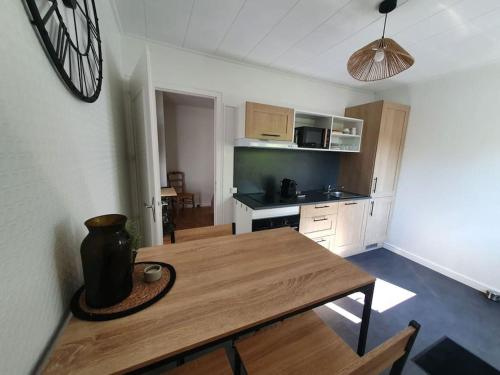 - une cuisine avec une table en bois dans une chambre dans l'établissement Les Pivoines, à Mont-sous-Vaudrey