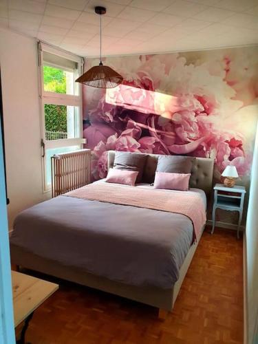 - une chambre avec un grand lit et un mur coloré dans l'établissement Les Pivoines, à Mont-sous-Vaudrey