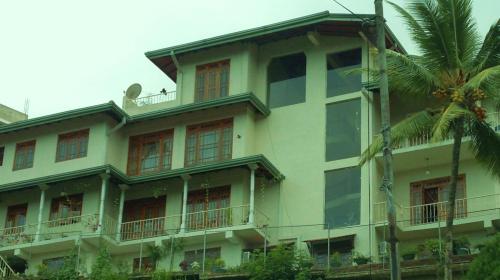 un edificio amarillo con ventanas y una palmera en Kandy Royal Resort, en Kandy