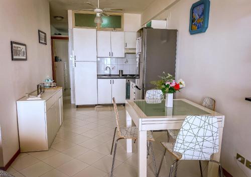 eine Küche mit einem Tisch und Stühlen sowie einem Kühlschrank in der Unterkunft Bellavista apartment Letojanni in Letojanni