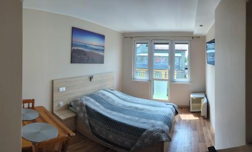 Pokoje Gościnne Bartek في ياستراوبيا جورا: غرفة نوم بسرير وطاولة ونوافذ