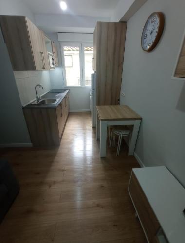 a kitchen with a sink and a clock on the wall at Xabucas in Pobra do Caramiñal