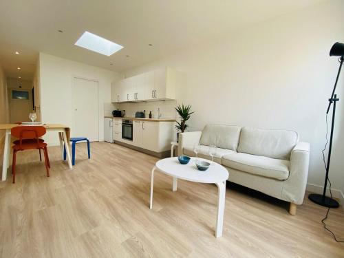 un salon avec un canapé blanc et une table dans l'établissement Casa Gardot, à Angers