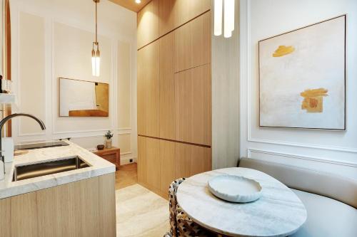 une petite cuisine avec une table et un évier dans l'établissement TheLander - Serviced Apartments in Louvre, à Paris