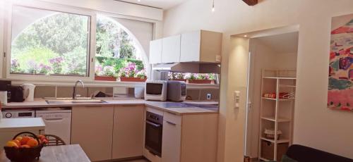 Una cocina con gabinetes blancos y un fregadero. en Lou Pitchoun, en Saint-Aygulf