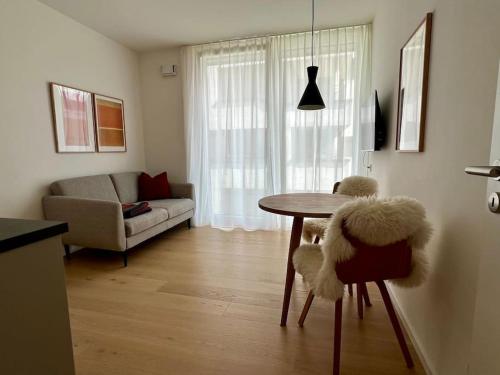a living room with a table and a couch at Schickes 2-Zi-Apartment am Neckarufer im BUGA-Park in Heilbronn