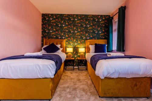 a bedroom with two beds and a wallpaper with flowers at Newly refurb 3 bed with parking in Stockton-on-Tees