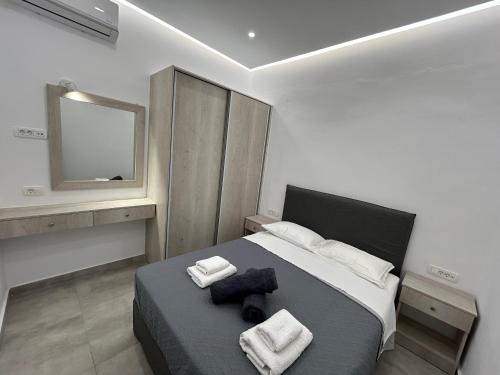 a bedroom with a bed with towels and a television at Aroma Cavas in Pyrgos
