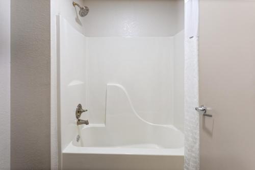 a bathroom with a shower with a faucet at Super 8 by Wyndham Prattville Montgomery in Prattville