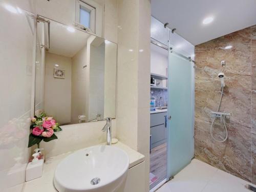 W łazience znajduje się umywalka i prysznic. w obiekcie Hanoi Home 2 - Lake View Apartment w mieście Hanoi
