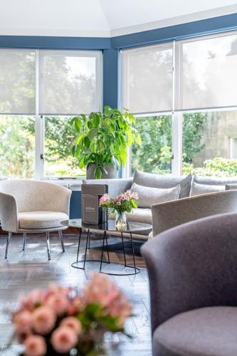 a living room with couches and chairs and windows at The Scholar in Edinburgh