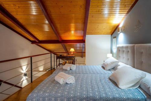- une chambre avec un grand lit et des serviettes dans l'établissement Dúplex apartamento Godoy Centro, à Cáceres