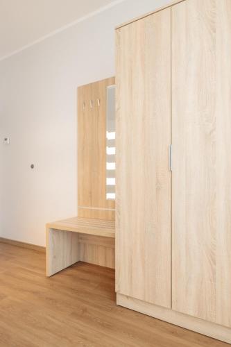a room with a wooden cabinet and a window at Baltic Apartments in Pobierowo
