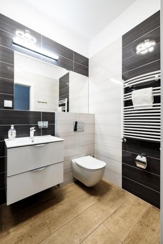 a bathroom with a white toilet and a sink at Baltic Apartments in Pobierowo