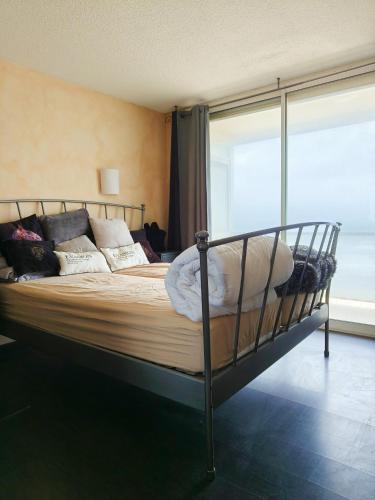 une chambre avec un lit avec des oreillers et une fenêtre dans l'établissement Duplex Exceptionnel Vue Mer, à Canet