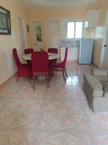 a living room with a table and chairs and a kitchen at Harbour Chateau in Odiongan