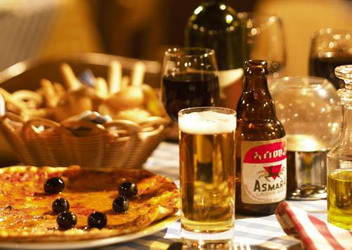 a table with a pizza and a bottle of beer at Hotel Asmara Palace in Asmara